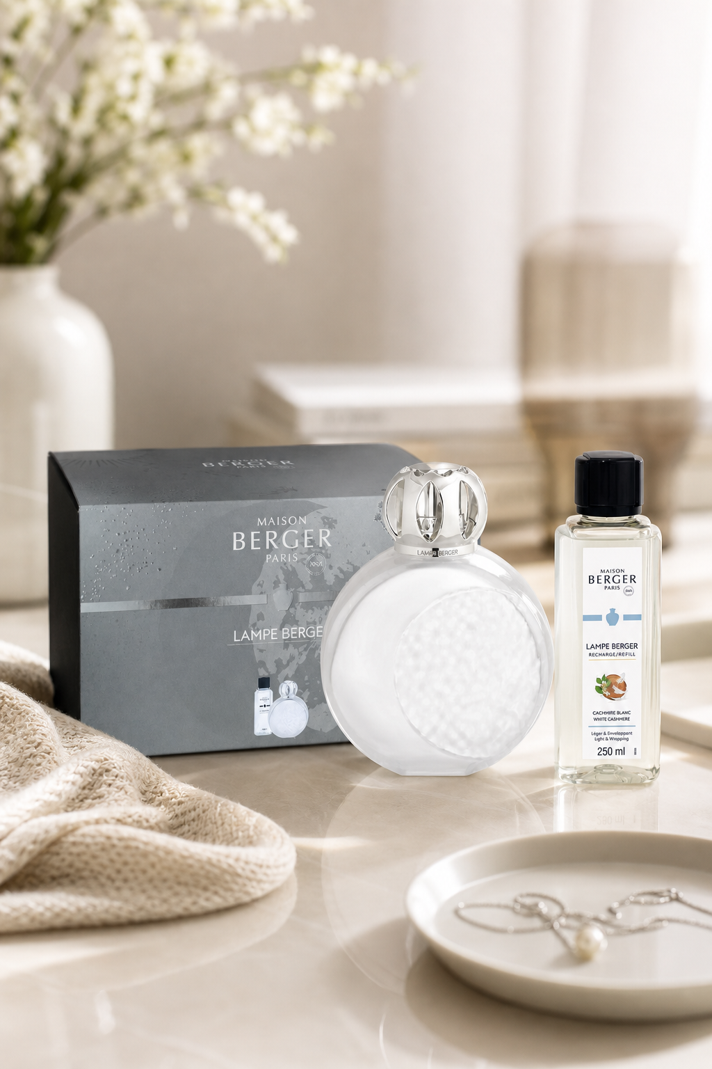 Weiße Lampe Berger mit Verpackung und Nachfüllflasche auf einem Tisch