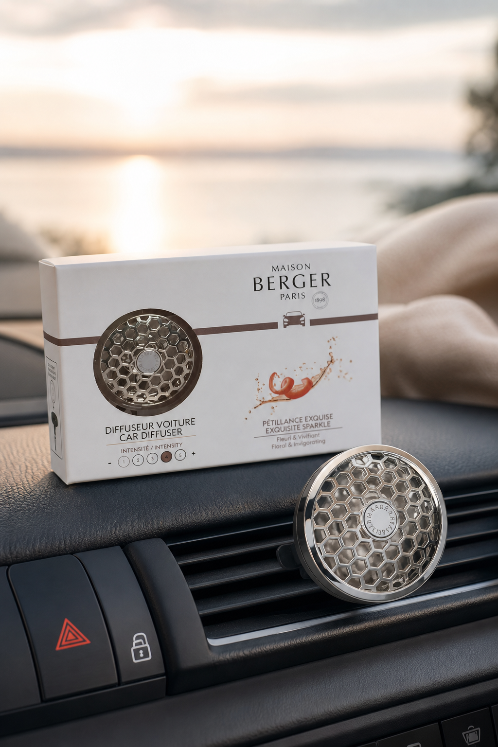 Maison-Berger-Autoduftspender auf dem Armaturenbrett neben seiner Verpackung