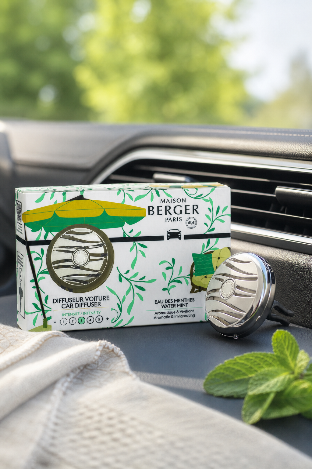 Autoduft-Set mit Verpackung und Diffusor vor einer Fahrzeuglüftung
