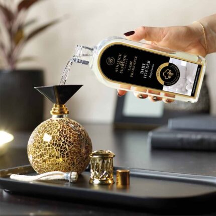 Baby Powder Lamp Fragrance wird aus einer Flasche in eine Duftlampe gegossen