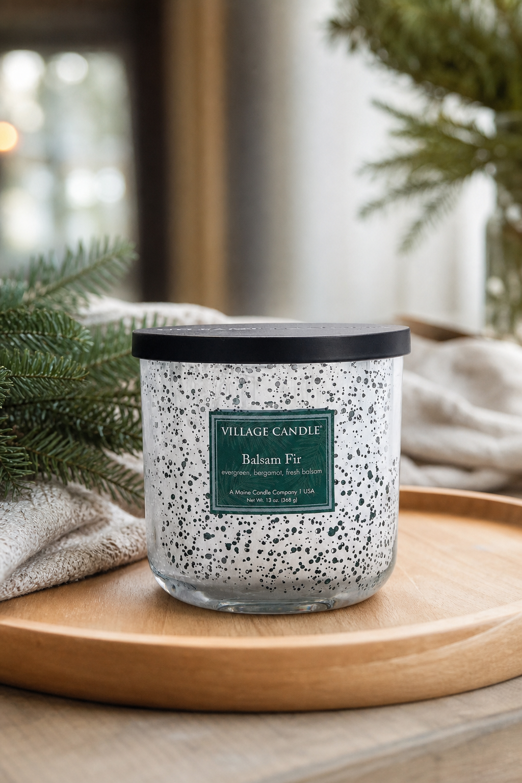 Balsam Fir Kerze auf Holztablett neben Tannenzweigen