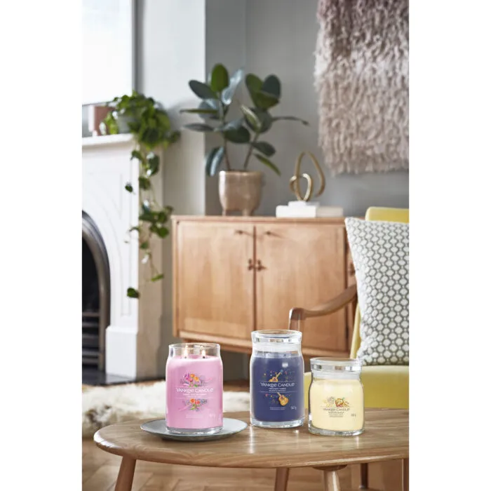 Drei Yankee Candle Duftkerzen vor einer Wohnzimmereinrichtung