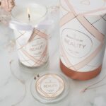 Geöffnete Beauty-Kerze neben Schmuck und Verpackung