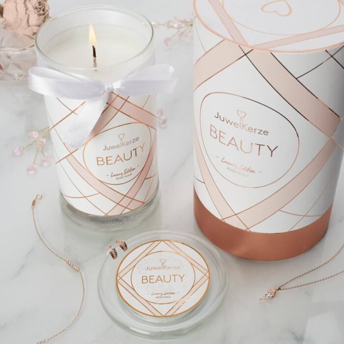Geöffnete Beauty-Kerze neben Schmuck und Verpackung