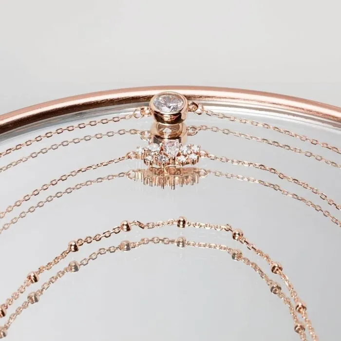 Roségoldfarbenes Schmuckarmband mit rundem Anhänger und Schmucksteinen