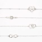 Mehrere Schmuckarmbänder mit Herz-, Unendlichkeits- und Verschlussmotiven