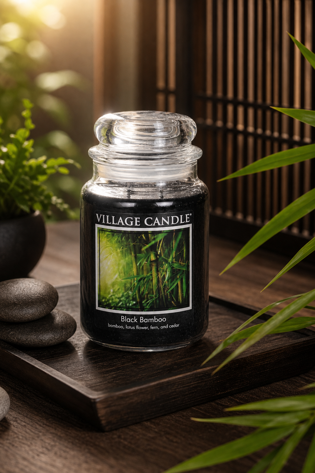 Village Candle Black Bamboo im Glas auf Holztablett mit Bambuspflanzen und Dekosteinen