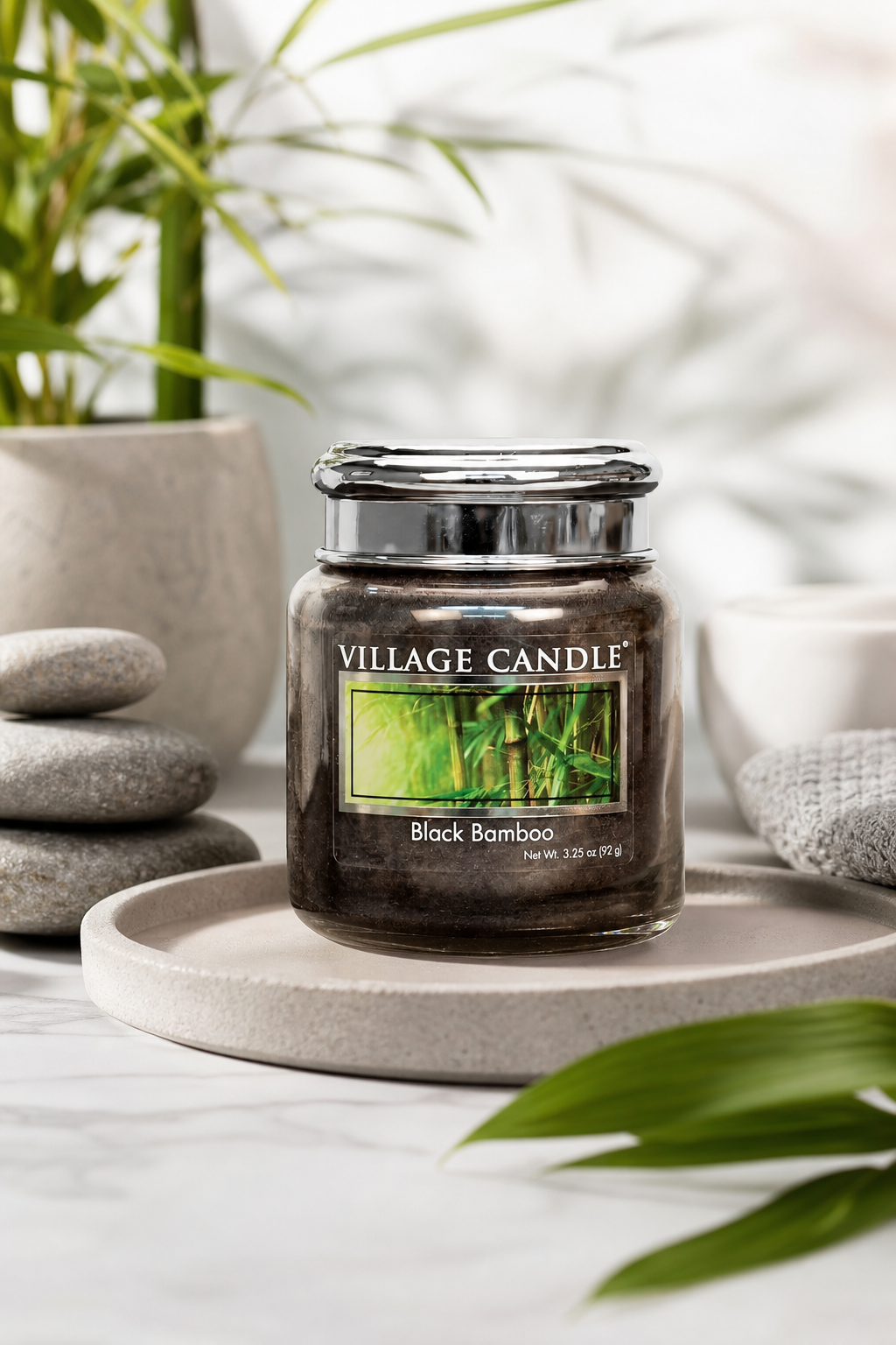 Verschlossenes Black-Bamboo-Glas auf einer Schale neben Steinen und Pflanzen