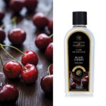 Black Cherry Duftölflasche mit lesbarem Ashleigh-&-Burwood-Etikett vor Kirschen