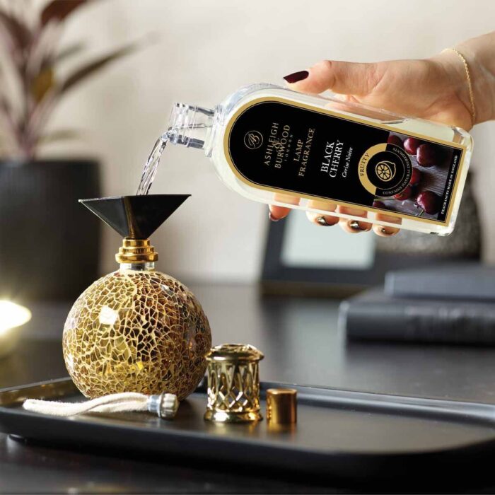 Hand gießt Black Cherry Lamp Fragrance in eine dekorative Duftlampe