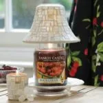 Brennende Black Cherry Kerze unter einem dekorativen Lampenschirm