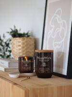 WoodWick Black Currant Rose Kerze neben weiteren Duftkerzen auf Beistelltischen