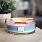 Brennende Trilogy-Kerze mit sichtbarer Flamme und Holzdocht