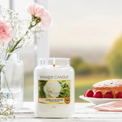 Brennende Yankee Candle Camellia Blossom Kerze auf gedecktem Tisch