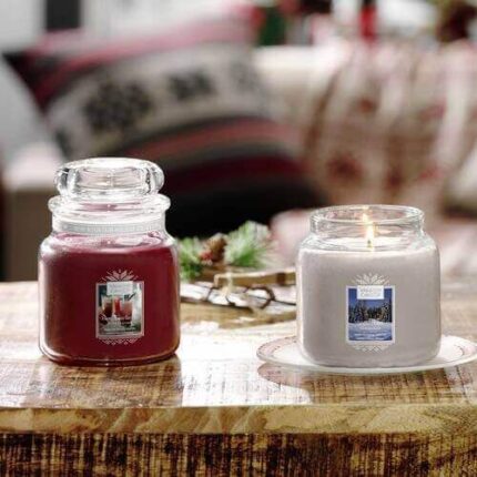Zwei Yankee-Candle-Gläser auf einem Holztisch, darunter Candlelit Cabin