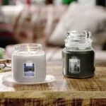 Candlelit Cabin im Glas neben einer grünen Yankee-Candle-Kerze auf Untersetzer