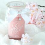 Halskette mit rundem Anhänger an einer rosa Kirschblütenkerze
