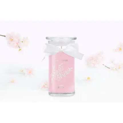 Rosa Kerze im Glas mit weißer Schleife und Kirschblütenmotiv