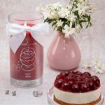 Cherry Kiss Kerze neben Kirschkuchen und rosa Vase