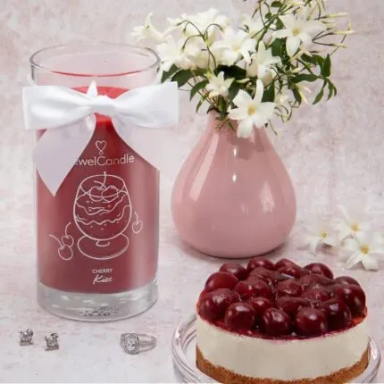 Cherry Kiss Kerze neben Kirschkuchen und rosa Vase