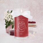 Rote Cherry Kiss Kerze mit weißer Schleife und brennender Flamme