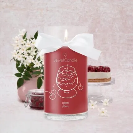Rote Cherry Kiss Kerze mit weißer Schleife und brennender Flamme