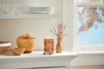 Yankee Candle Cinnamon Stick Duftkerze steht neben Vase und Obstschale