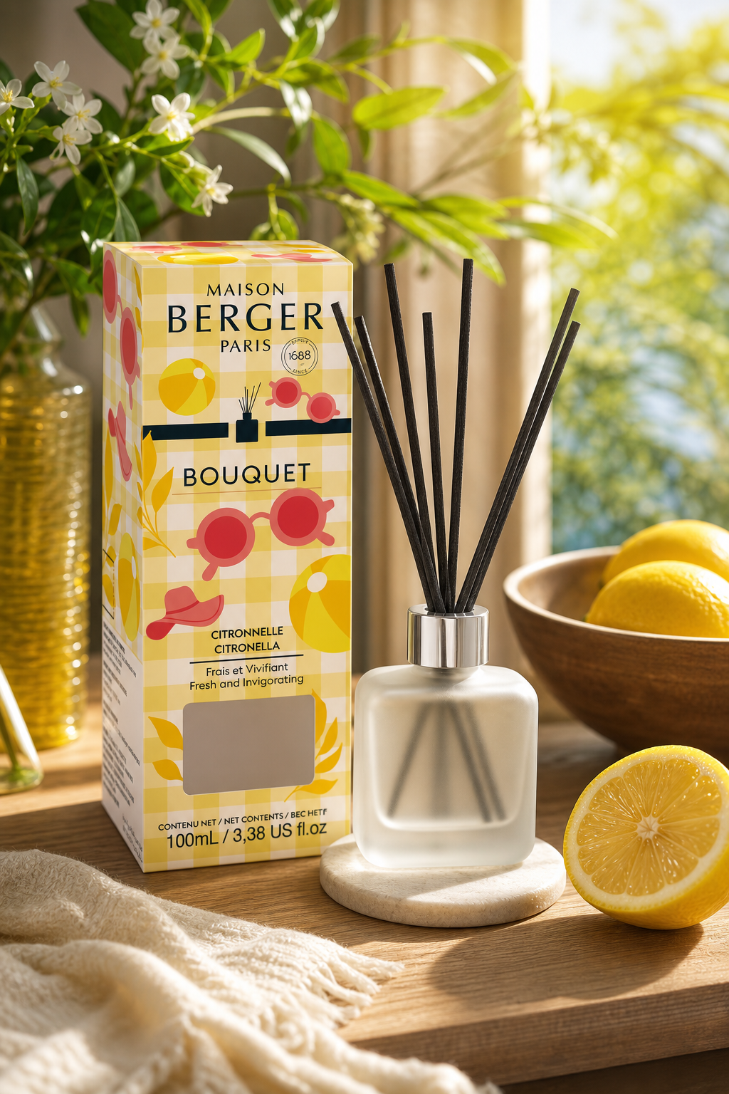 Citronella Diffuser mit Verpackung, Zitronen und Pflanzen auf einem Tisch