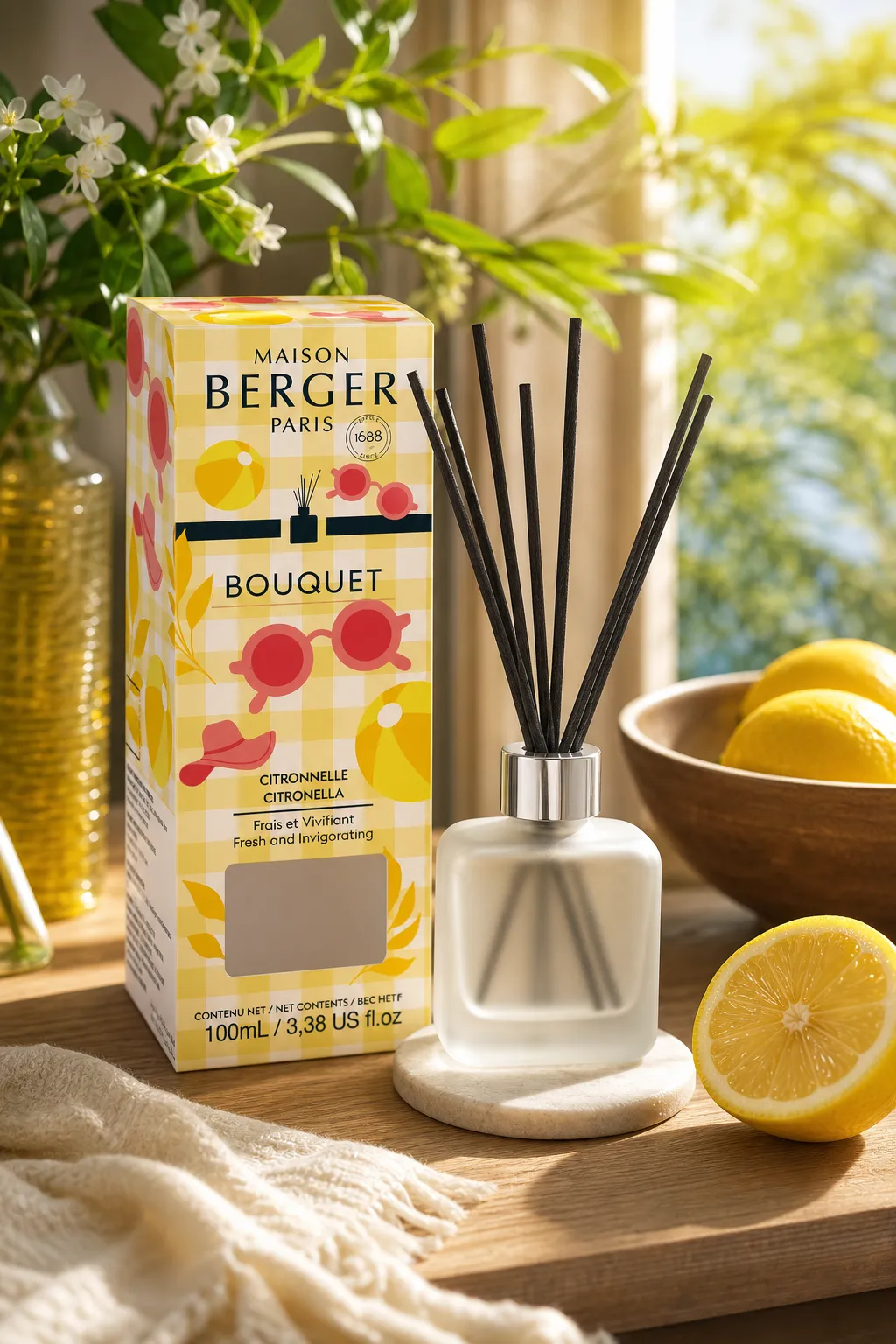 Citronella Diffuser mit Verpackung, Zitronen und Pflanzen auf einem Tisch