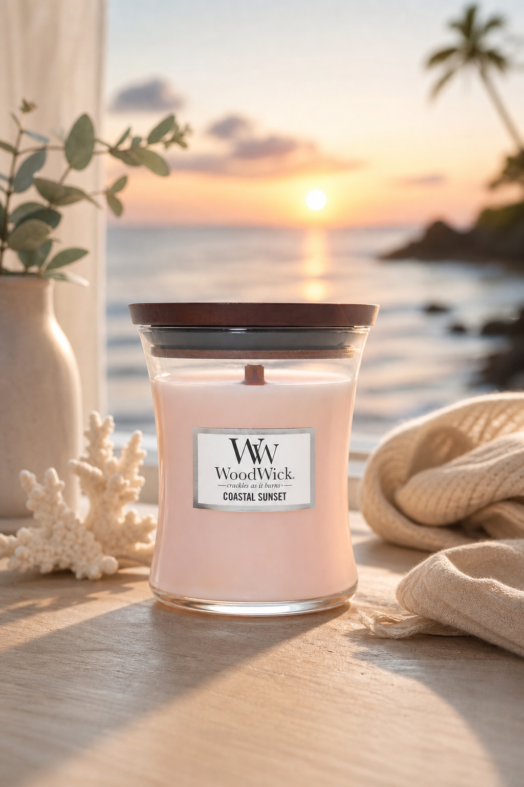 WoodWick Coastal Sunset Kerze vor einem Sonnenuntergang am Meer