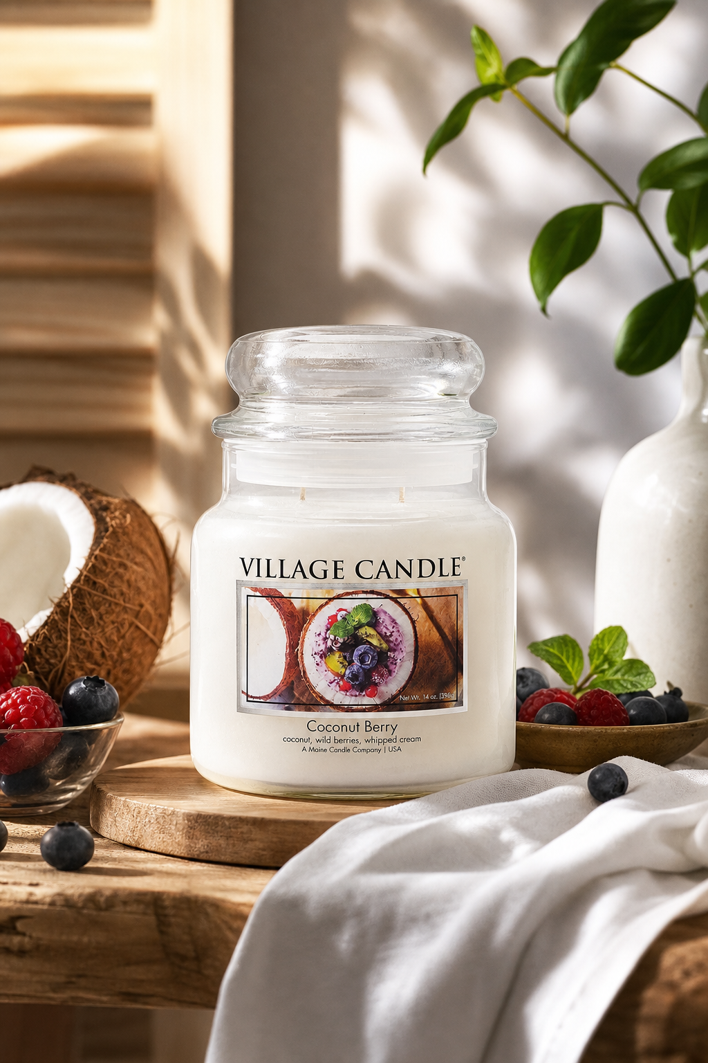 Village Candle Coconut Berry Kerze auf Holztisch mit Kokosnuss und Beeren