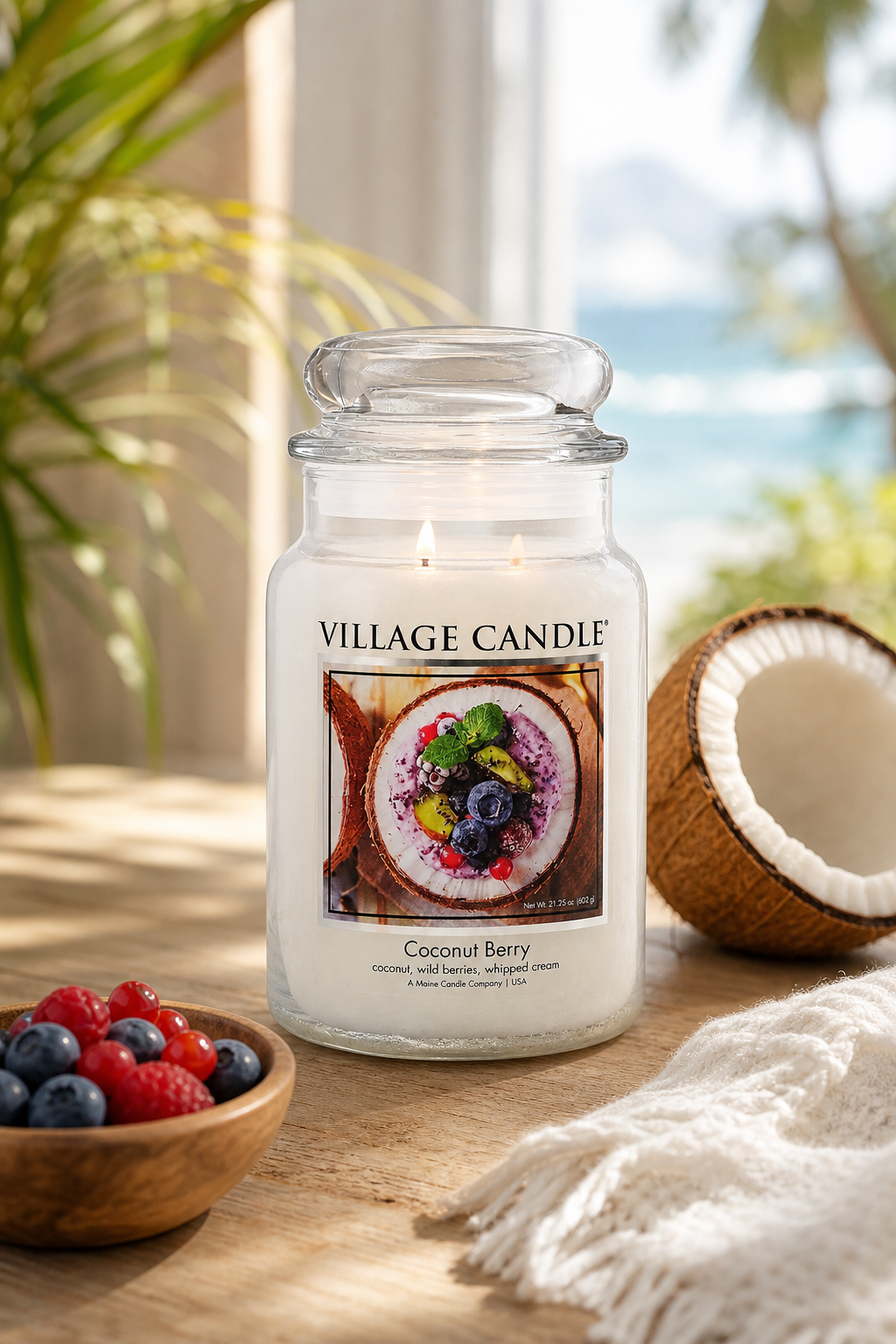 Coconut Berry Kerze im Glas brennt auf Holztisch neben Kokosnusshälfte