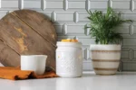 Weiße Cookie Jar Duftlampe mit Wachsstücken neben Pflanze und weißem Gefäß