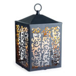 Schwarze Laterne mit ornamentalen Ausschnitten und warmem Licht