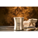Fünf WoodWick Kerzen, darunter Cypress Ore, auf reflektierender Oberfläche