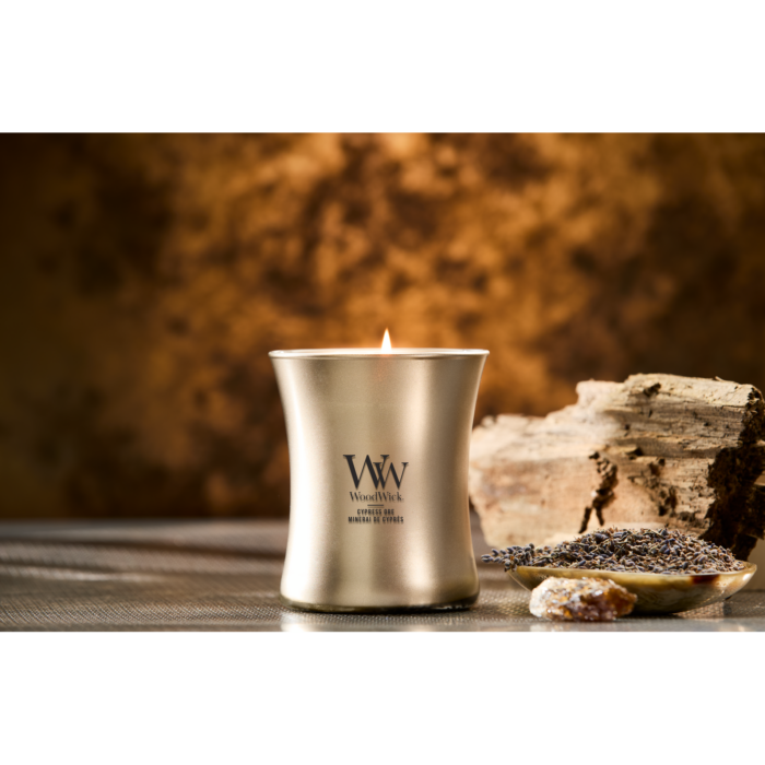 Fünf WoodWick Kerzen, darunter Cypress Ore, auf reflektierender Oberfläche