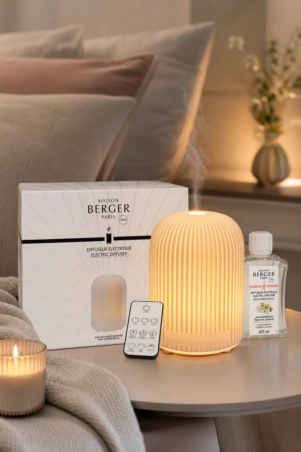 Diffuser im Schlafzimmer Beleuchteter elektrischer Diffuser mit Verpackung und Jasmin-Nachfüllflakon auf einem Tisch