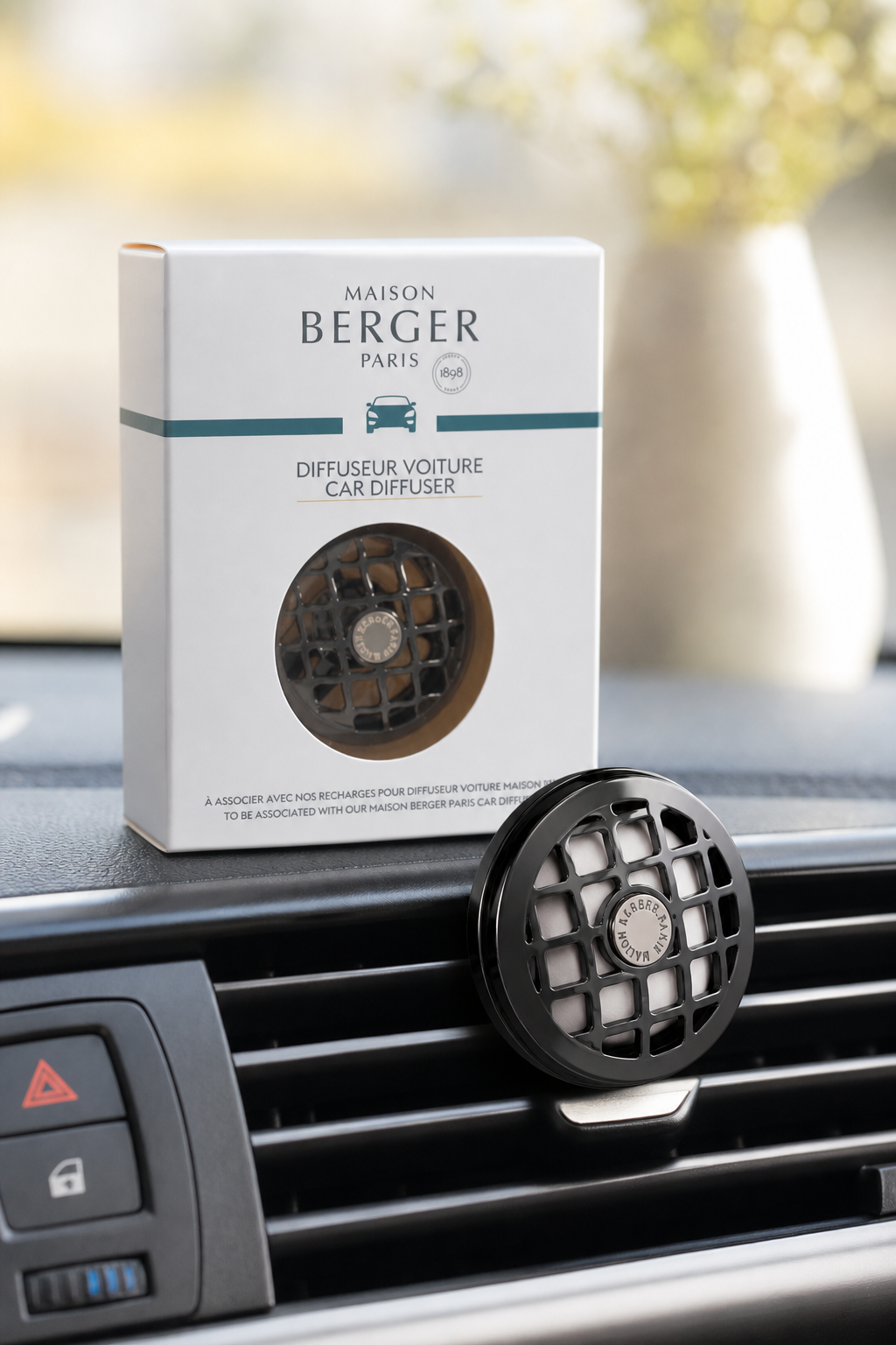 Autoduft-Diffuser an einer Lüftung im Auto neben seiner Verpackung
