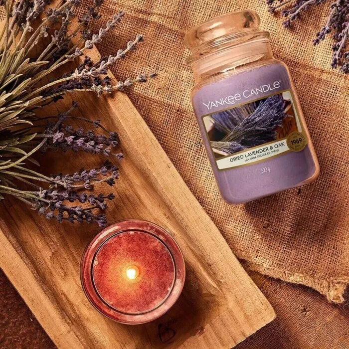Yankee Candle Dried Lavender & Oak liegt neben Lavendel auf Holzbrett