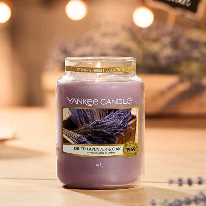 Yankee Candle Dried Lavender & Oak steht angezündet auf einem Holztisch