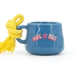 Rückansicht einer blauen Tassenkerze mit gelber Kordel und HUG IT OUT