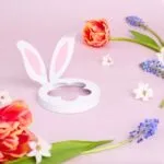 Weißer Lid mit Hasenohren und blütenförmiger Öffnung auf rosa Untergrund