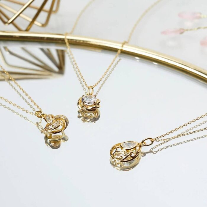 Person hält eine große Elegance Kerze neben einer goldenen Geschenkbox