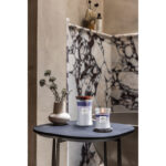 Zwei Trilogy Evening Luxe Kerzen neben einer Vase auf einem Tisch