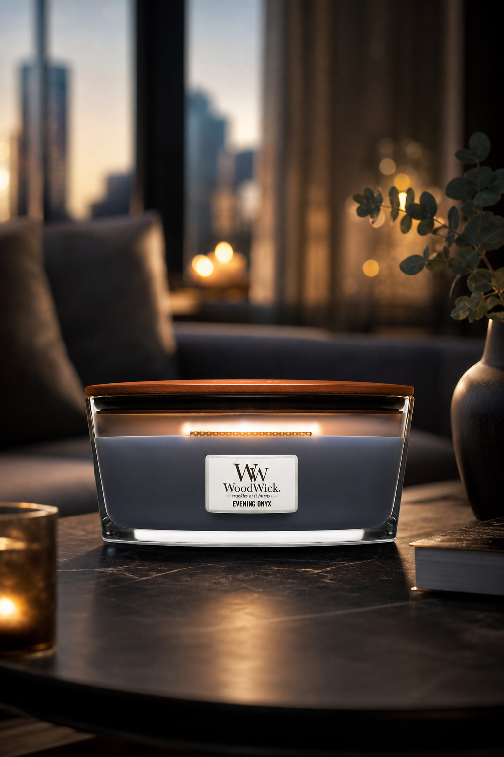 WoodWick Evening Onyx Kerze mit brennendem Docht auf einem Tisch
