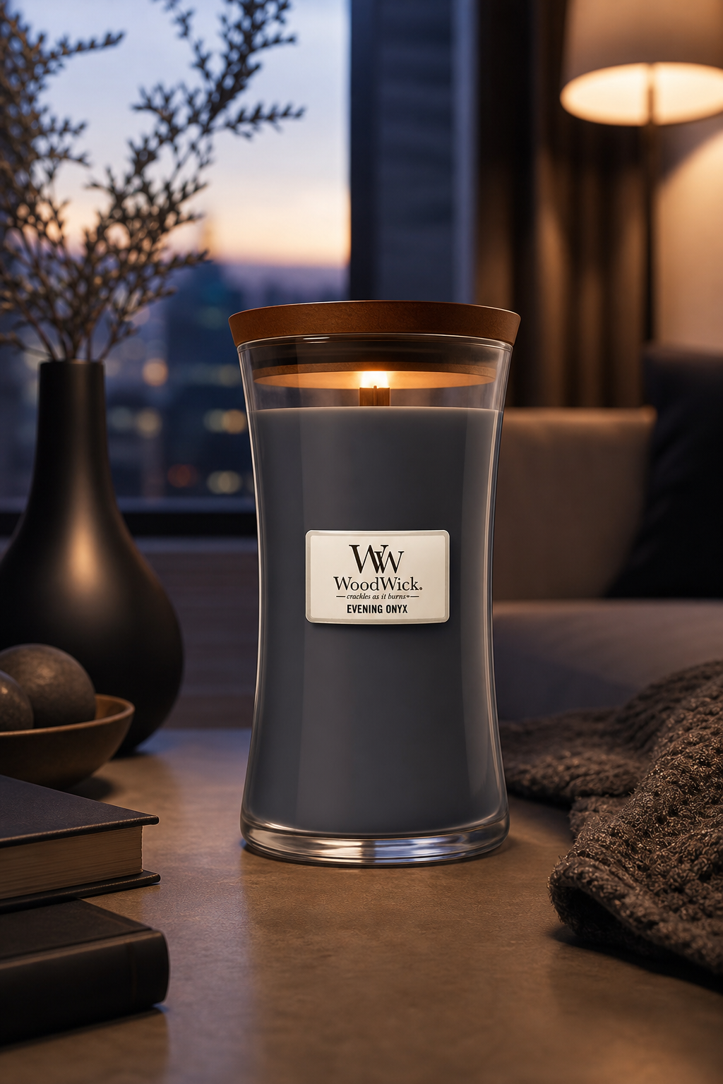 Brennende WoodWick Evening Onyx Kerze auf einem Tisch in Wohnumgebung
