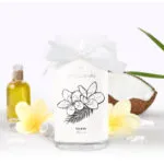 Weiße JewelCandle Kerze Fleur de Monoi mit Schleife und Blumenmotiv