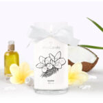 Weiße JewelCandle Fleur de Monoi Kerze mit Schleife und brennendem Docht
