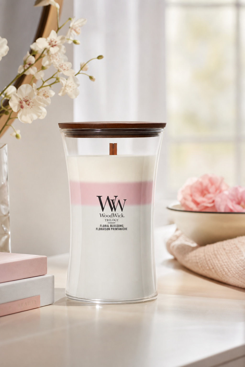WoodWick Floral Blossoms Kerze mit Holzdeckel auf einem Tisch im Wohnambiente