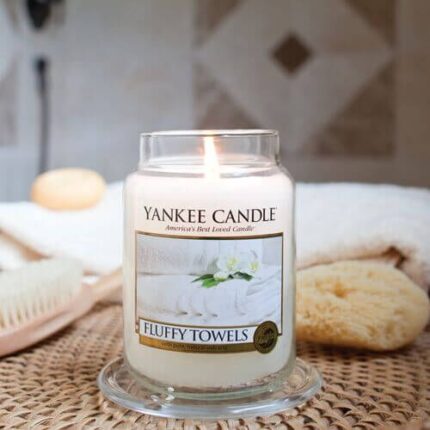 Brennende Yankee Candle Fluffy Towels Kerze auf Glasuntersetzer